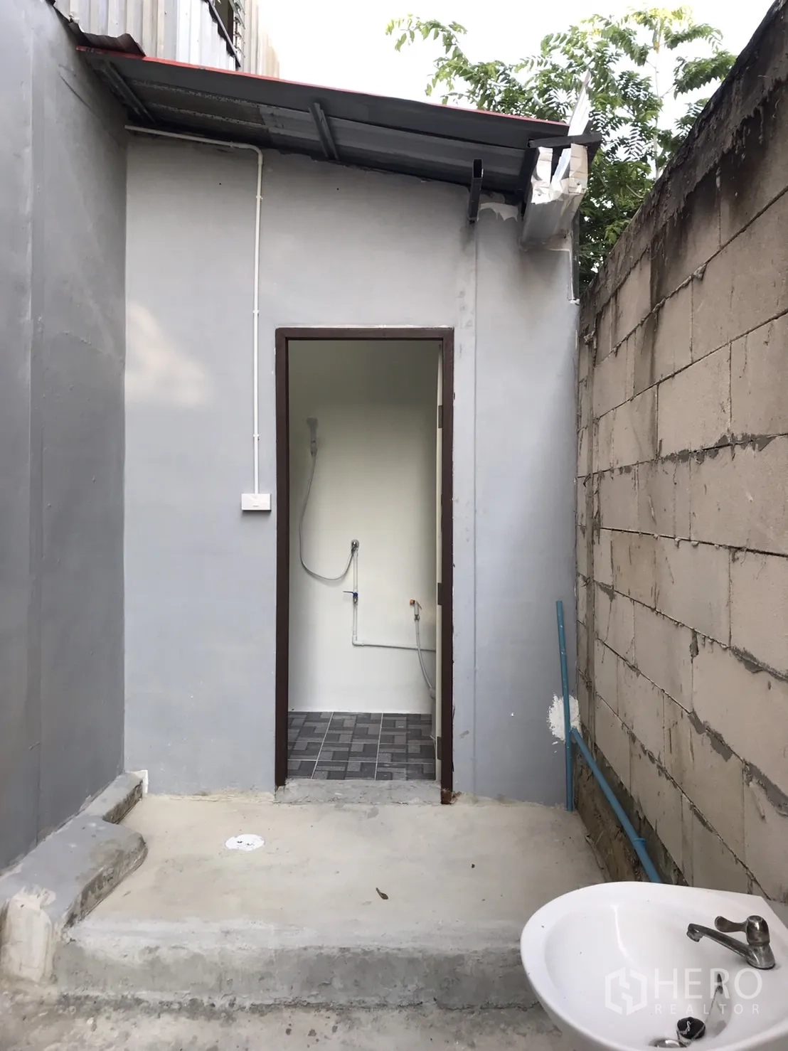 Warehouse for rent in Lam Luk Ka, Pathum Thani - Exterior utility zone with bathroom access and wall-mounted sink.
