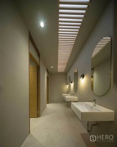 Home Office for sale in Wang Thonglang, Bangkok - Hallway wash area with skylight slats, mirrors and wall sconces above white basins.