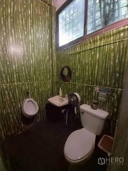 Shophouse for rent in Khlong Toei, Bangkok - Restroom with bamboo-patterned tiles, toilet, urinal and small sink.