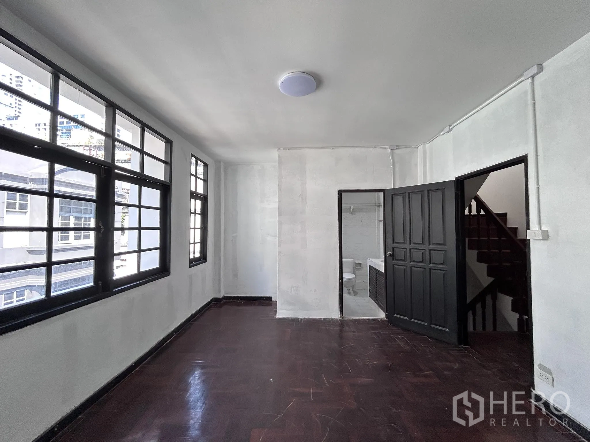 Home Office for rent or sale in Watthana, Bangkok - Corner room with wood flooring, large windows and ensuite bathroom entrance.