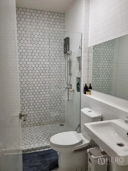 Townhouse for rent - Bright bathroom with glass shower, hexagon tiles and white fixtures.