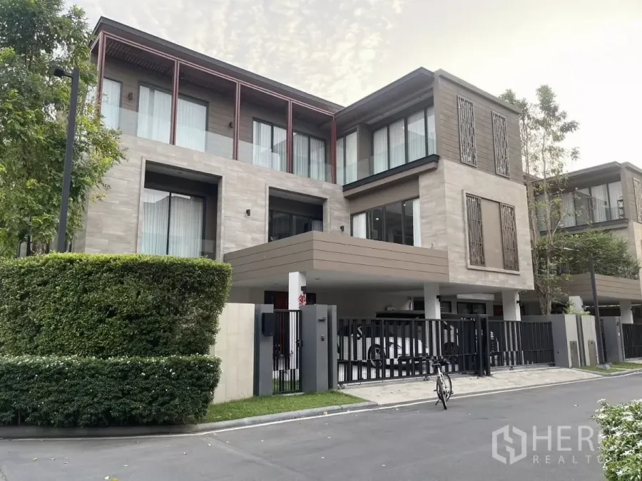 Detached House for rent or sale in Bang Kapi, Bangkok - Modern three-storey detached house facade with gated driveway, hedges and covered carport in Bang Kapi, Bangkok.