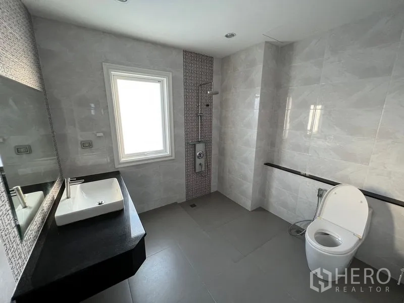 Home Office for rent or sale - Modern bathroom with window, tiled walls, walk-in shower and toilet.