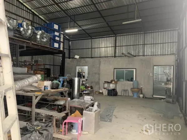 Warehouse for rent in Bang Kapi, Bangkok - Open-plan warehouse floor showing concrete slab, office pod and mezzanine platform.