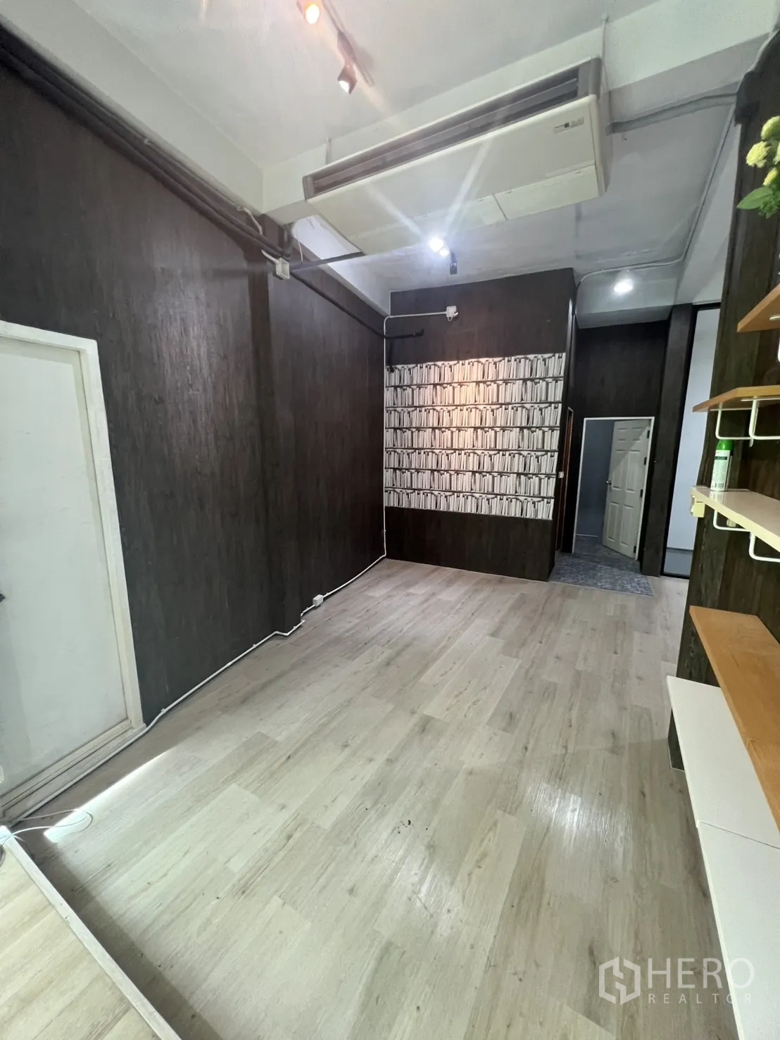 Retail Space for rent in Watthana, Bangkok - Narrow display room with ceiling air‑conditioning unit, wall shelves and light laminate floors.