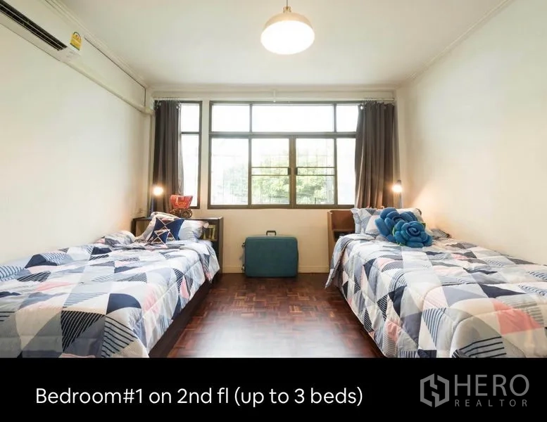 Townhouse for rent in Khlong Toei, Bangkok - Bright second-floor bedroom with two single beds and a wide window.
