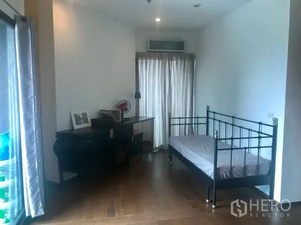 Condominium for rent in Khlong Toei, Bangkok - Bright secondary room with single daybed, study desk and floor-to-ceiling window.