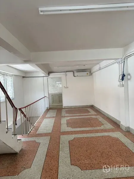 Shophouse for rent in Bangkok - Open-plan upper floor with terrazzo tiles and staircase access.
