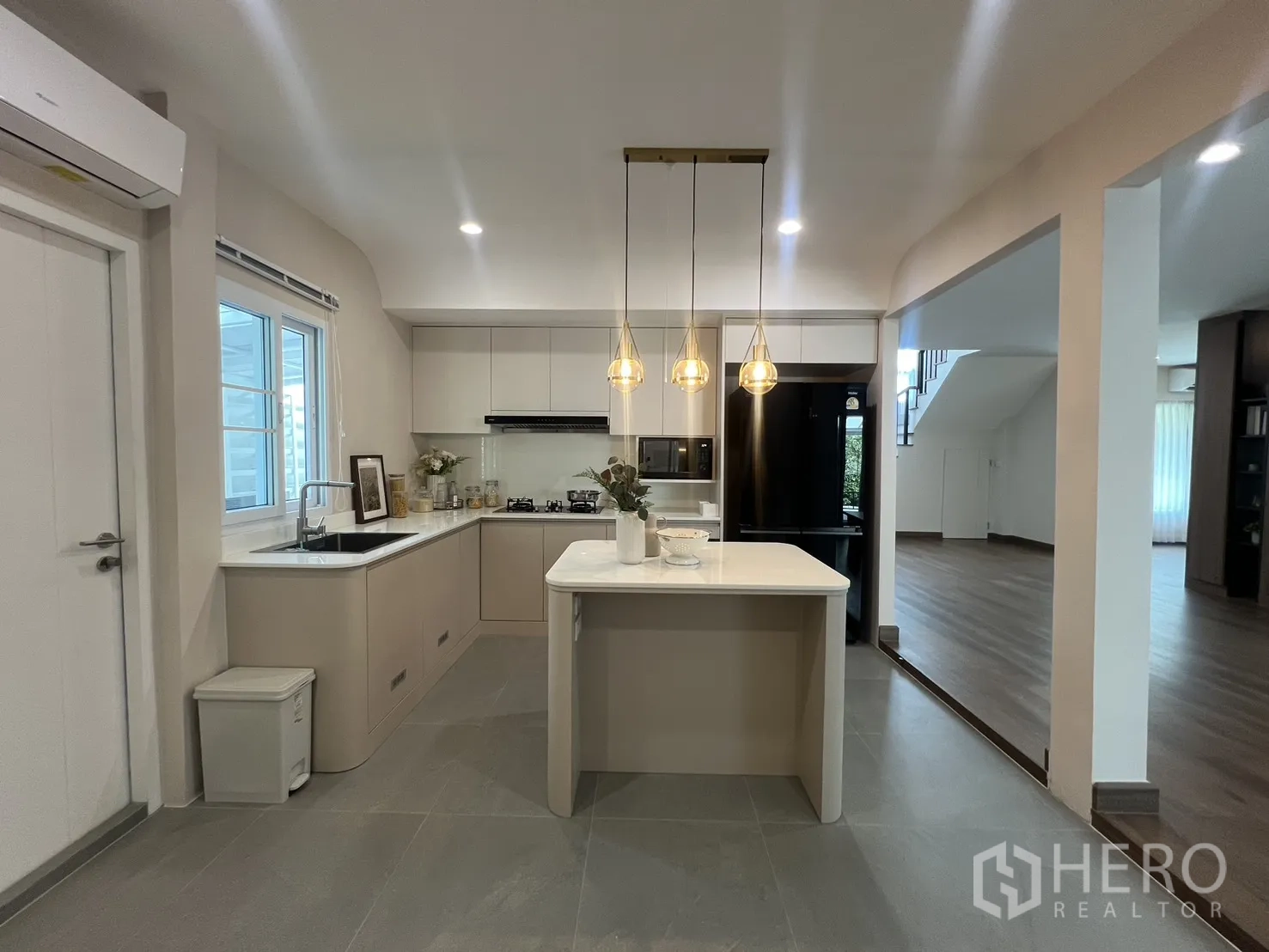 Detached House for rent in Mueang Samut Prakan, Samut Prakan - Kitchen with island, black refrigerator and soft-tone cabinets.