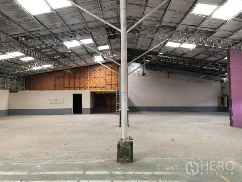 Warehouse for rent in Sai Mai, Bangkok - Open-plan storage area with high ceiling, mezzanine room, and ladder inside the warehouse.