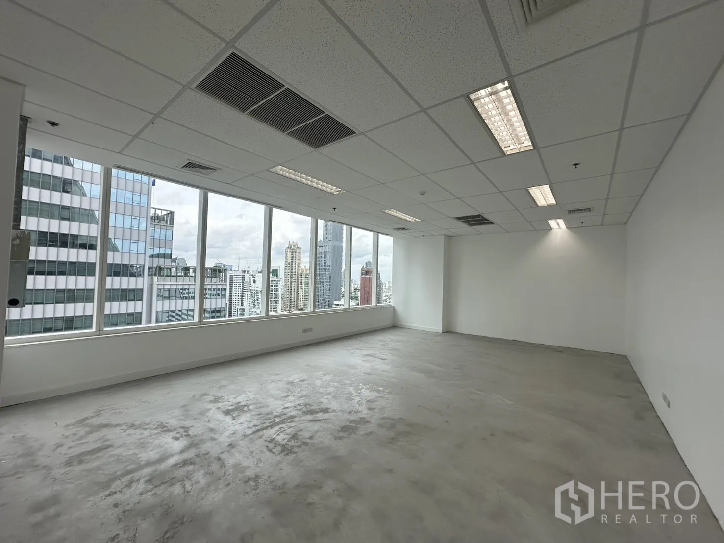 Office Space for rent in Watthana, Bangkok - Spacious corner office area with air-conditioning vents and fluorescent lights.