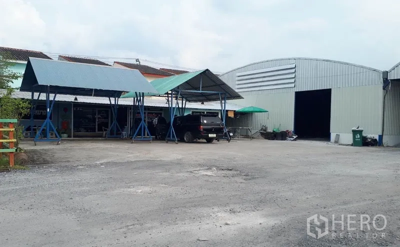 Warehouse for rent in Nong Chok, Bangkok - Exterior view of the warehouse compound with metal sheds, parking area and main loading entrance.