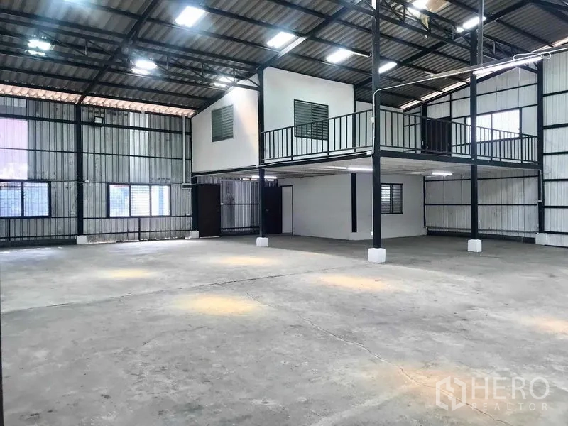 货栈 出租在Pathum Thani - 采光明亮的仓库地面，天窗、高屋顶和架空办公室。