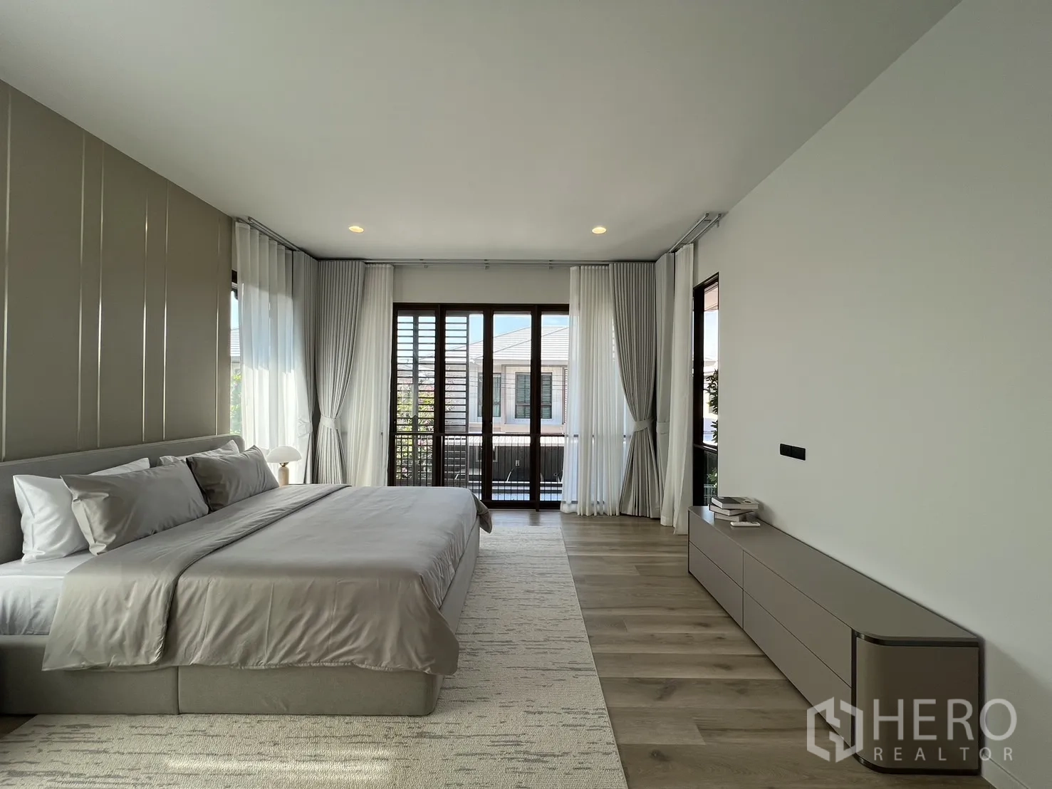Detached House for rent or sale in Bang Kapi, Bangkok - Expansive master bedroom with balcony access and large windows.