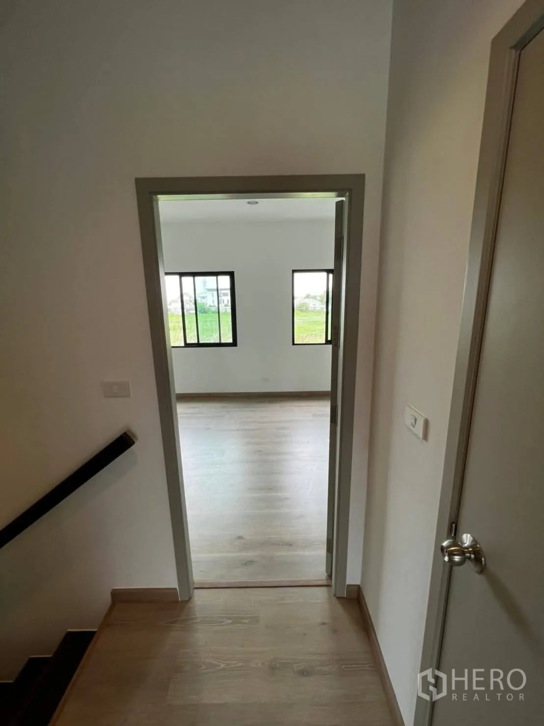 Townhouse for rent in Bang Khen, Bangkok - Bathroom with marble-style tiles, wall-length mirror, and door to adjacent room.
