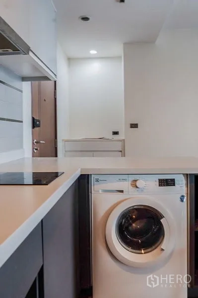 Condominium for rent in Khlong Toei, Bangkok - Dining table for four facing a large mirror beside the living area and bathroom door.