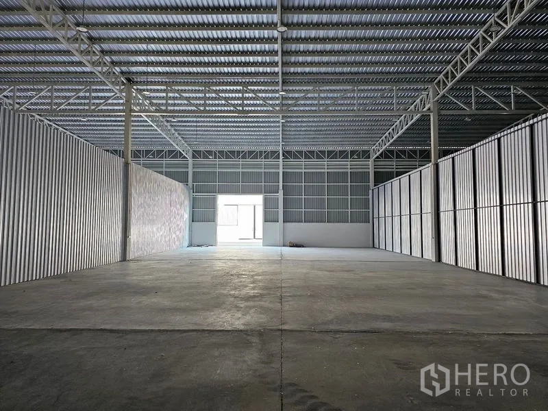Warehouse for rent in Khlong Toei, Bangkok - Open warehouse bay with metal cladding and a central opening to an adjoining unit.