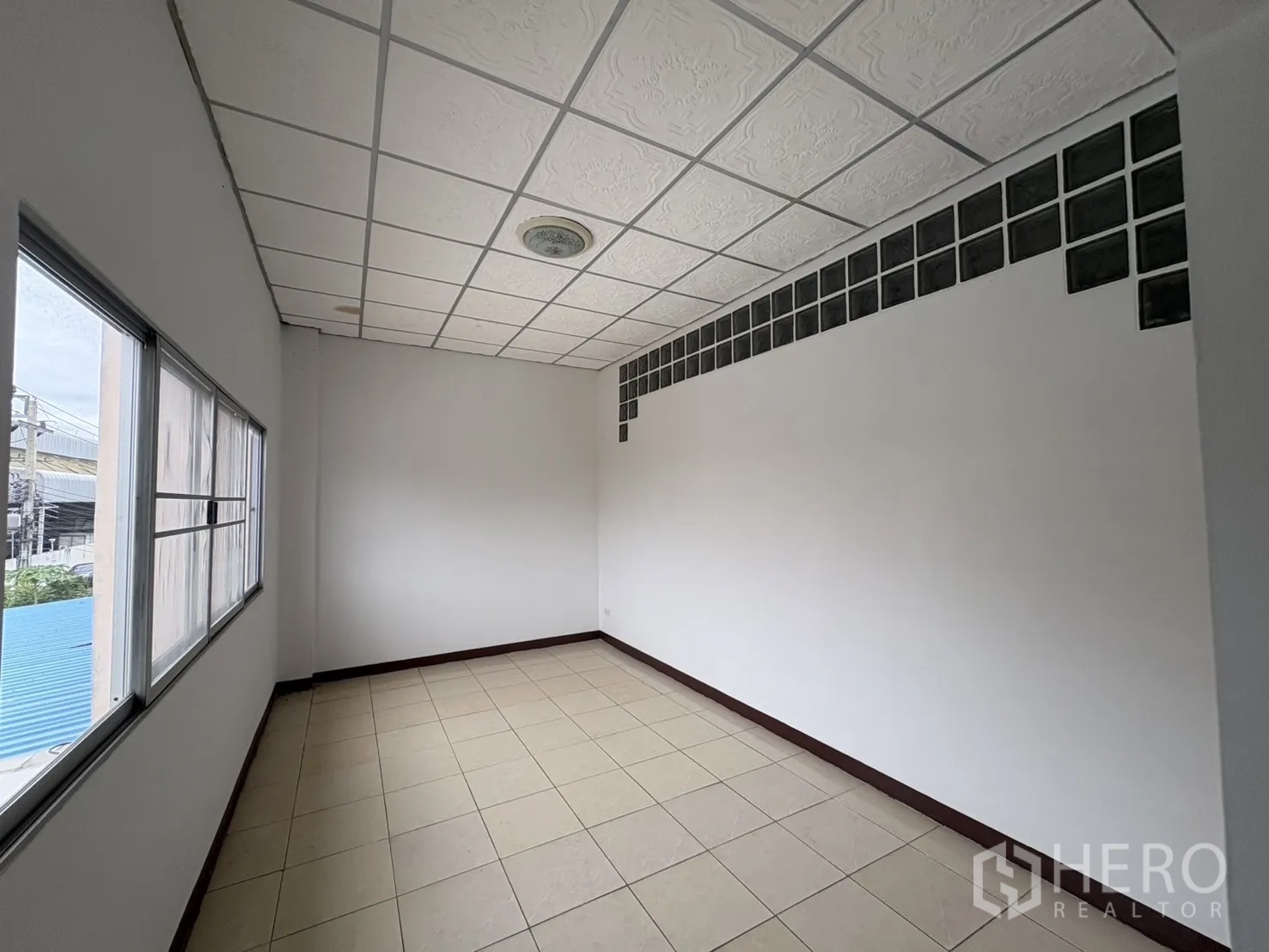 Warehouse for rent in Bang Phli, Samut Prakan - Slim office with glass-block detail and side windows.