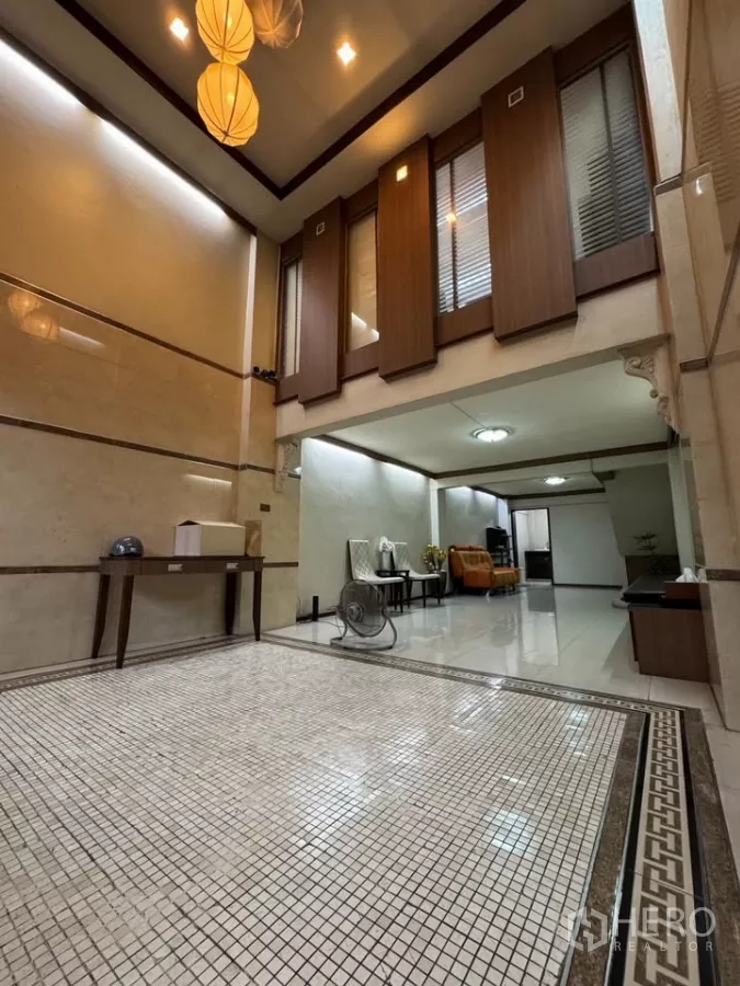Shophouse for rent in Bang Rak, Bangkok - Double-height entry hall with mosaic flooring, pendant lights, and seating area.
