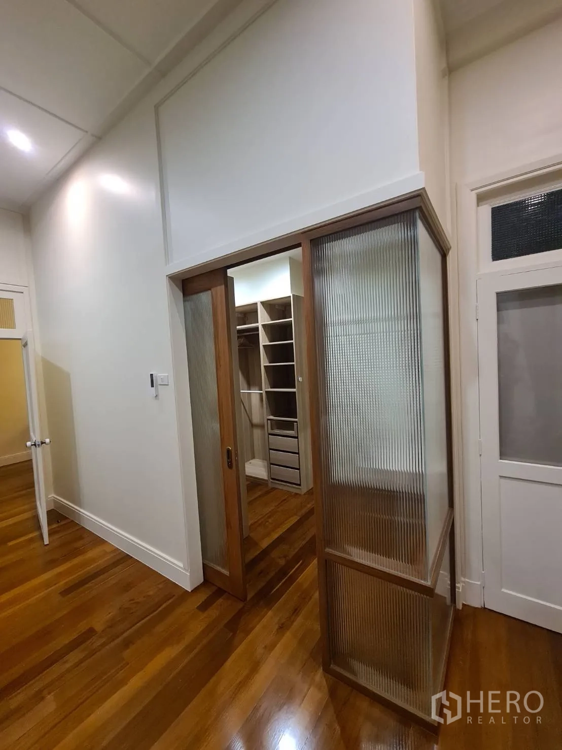 Detached House for rent in Khlong Toei, Bangkok - Hallway with sliding glass door opening to a fitted wardrobe room.
