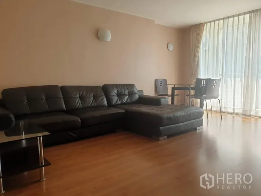 Condominium for rent or sale in Watthana, Bangkok - Bright living room with black leather sectional, dining set and floor-to-ceiling windows