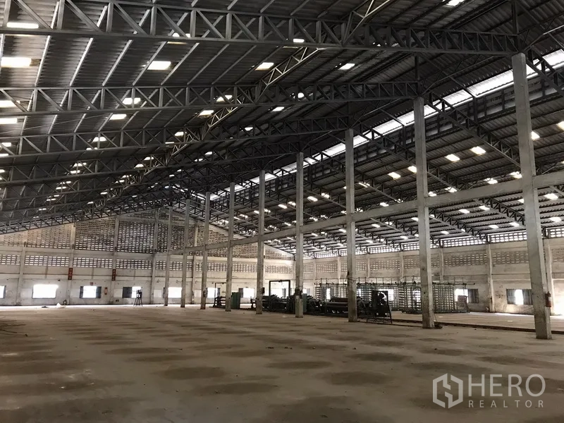 Warehouse for rent in Phra Pradaeng, Samut Prakan - Wide-span industrial hall with concrete columns, ample lighting and ventilation blocks.
