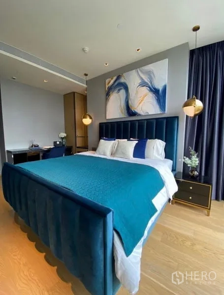Condominium for rent - Spacious bedroom showing blue bedframe, pendant lights, study desk and wood flooring.