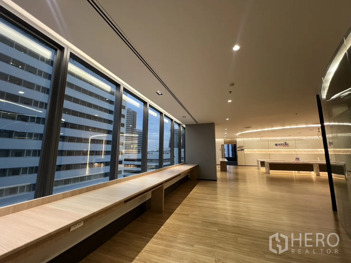 办公空间 出租在Huai Khwang, Bangkok - 开放办公区，落地窗、带插座的长工作台与城市天际线。