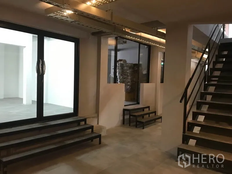 办公空间 出租在Watthana, Bangkok - 大厅区域，金属楼梯、玻璃隔断与多级台阶通向各室。