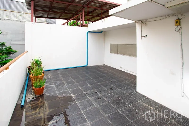 Townhouse for rent in Khlong Toei, Bangkok - Private tiled terrace with utility piping, ideal for laundry or storage.