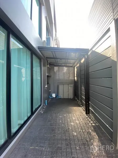 联排别墅 出租在Saphan Sung, Bangkok - 带顶棚的侧院与家务区，隐私围栏与推拉玻璃门相连室内。