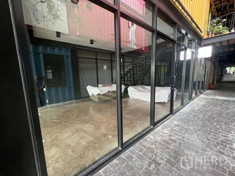 Retail Space for rent - Shopfront along an internal courtyard with full-height glass and a staircase leading to upper levels.