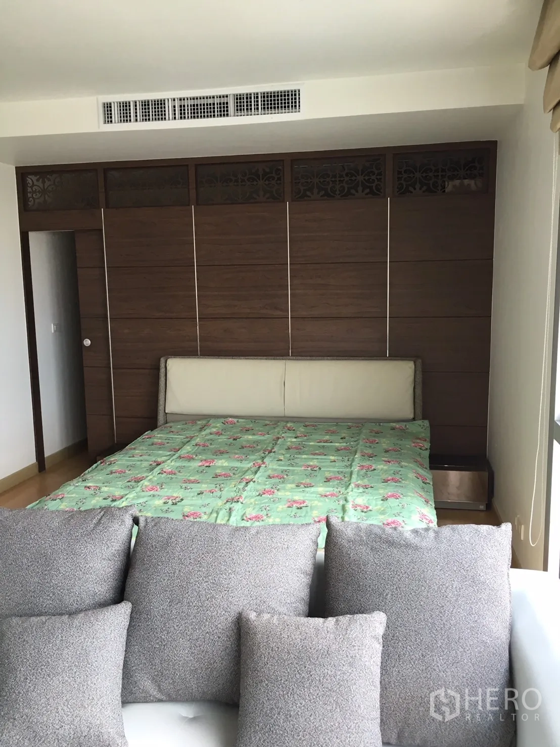 Condominium for rent or sale in Khlong Toei, Bangkok - Master bedroom featuring a wood built-in wardrobe wall and bed in neutral tones.