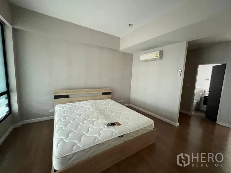 Townhouse for rent or sale in Khlong Toei, Bangkok - Bright bedroom with a bed, air conditioning and wood flooring.