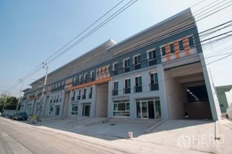 Factory for rent in Bang Sao Thong, Samut Prakan - Alternate angle of the complex exterior with power lines and access road.