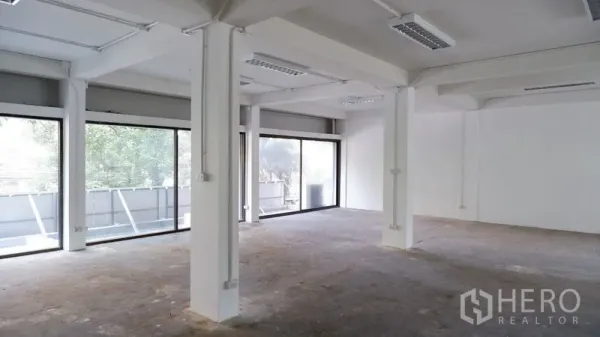 Office Space for rent in Watthana, Bangkok - Large open-plan office with white columns and wall-length windows bringing natural light.