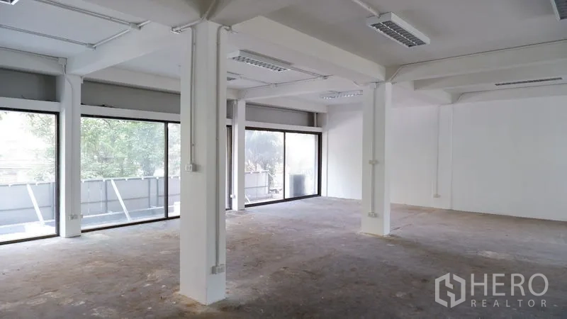 Office Space for rent in Watthana, Bangkok - Large open-plan office with white columns and wall-length windows bringing natural light.