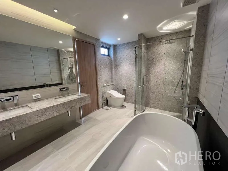 Townhouse for rent in Phra Khanong, Bangkok - Luxury bathroom with freestanding bathtub, double vanity and glass shower.