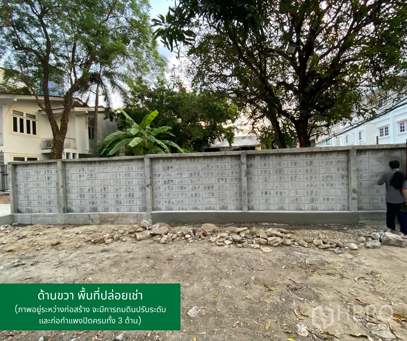 Land for rent in Phaya Thai, Bangkok - Side boundary wall of the land with mature trees along neighboring properties.