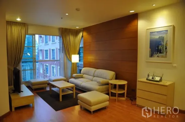Condominium for rent or sale in Khlong Toei, Bangkok - Corner living room featuring large windows, coffee table set and modern décor.