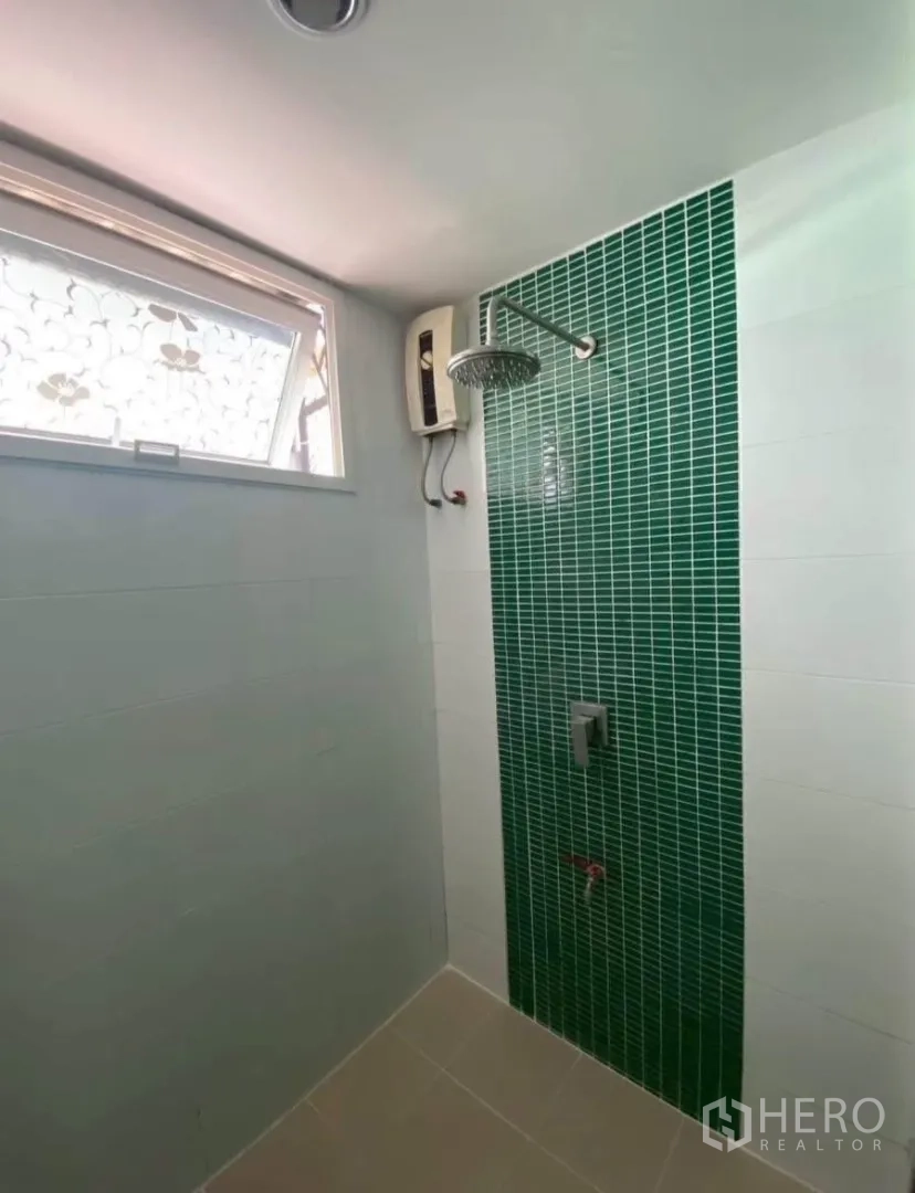 Townhouse for rent in Phra Khanong, Bangkok - Walk-in shower with green mosaic accent tile, window, and electric water heater.