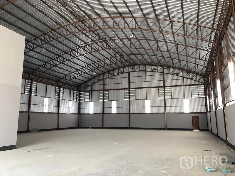 Factory for rent or sale in Bang Len, Nakhon Pathom - Spacious warehouse interior featuring a high arched steel roof, ventilation panels and concrete flooring.