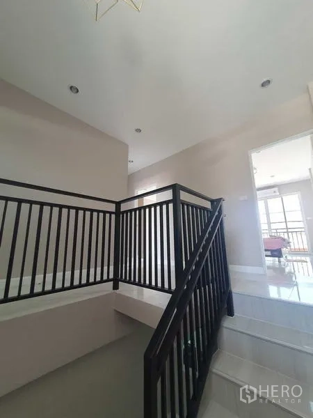 Home Office for rent in Suan Luang, Bangkok - Upper floor landing with black railing and ceiling lights.
