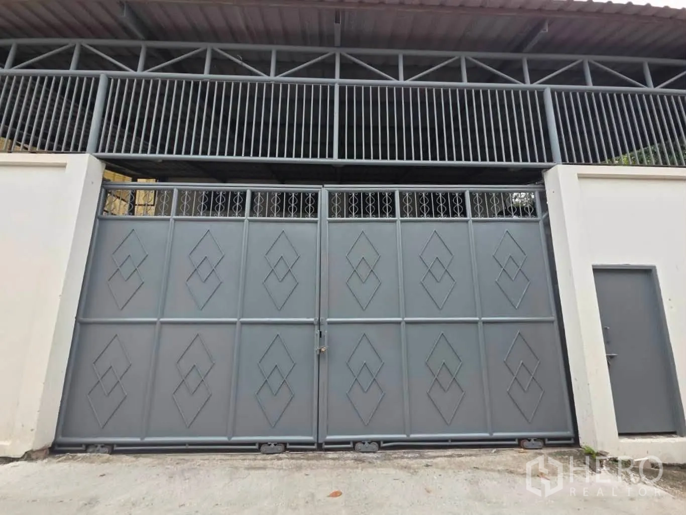 Warehouse for rent or sale in Phra Khanong, Bangkok - Secure street-facing metal gate and pedestrian door to the compound.