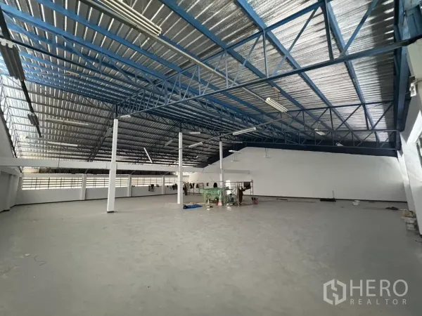 Factory for rent in Khlong Toei, Bangkok - Spacious factory floor with insulated roof panels and fluorescent lighting.