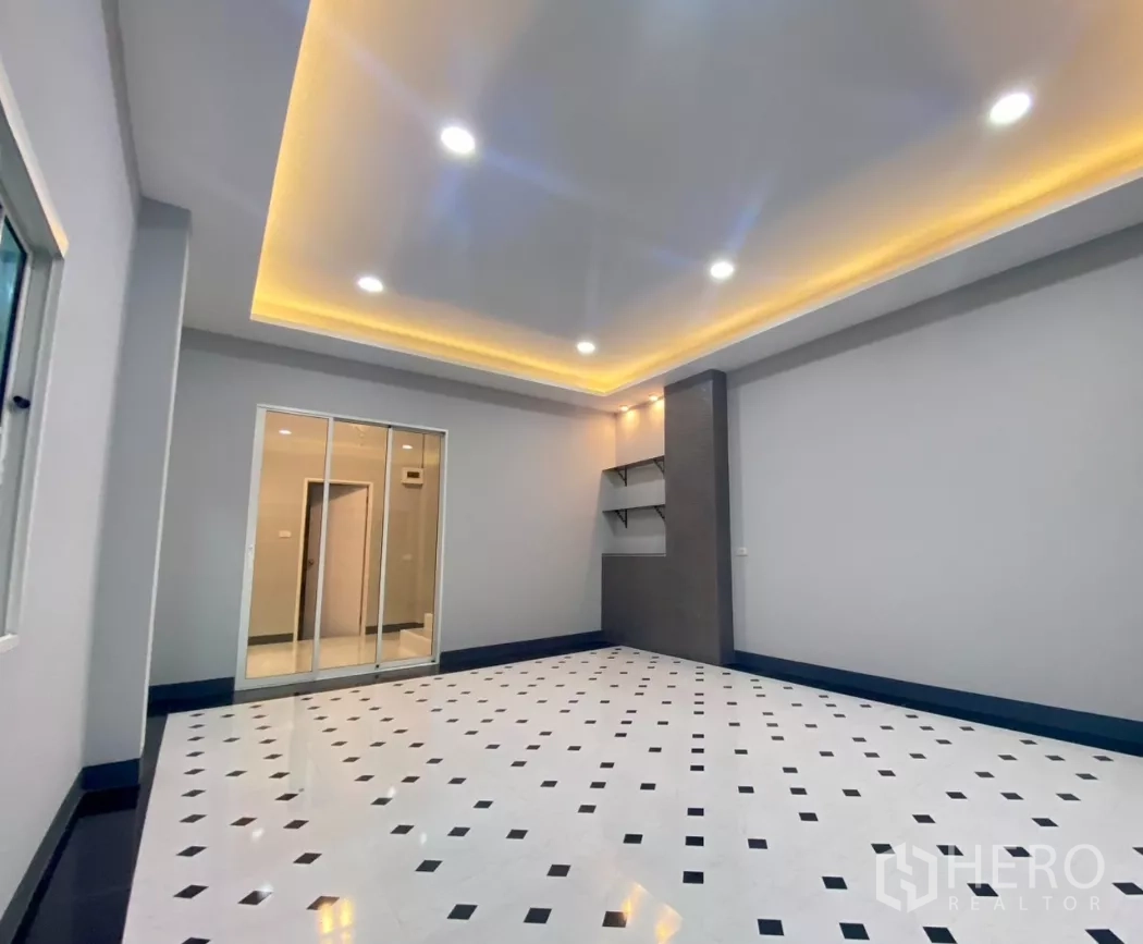 Factory for rent or sale in Bang Bua Thong, Nonthaburi - Office lounge with recessed LED cove lighting and built-in shelving.