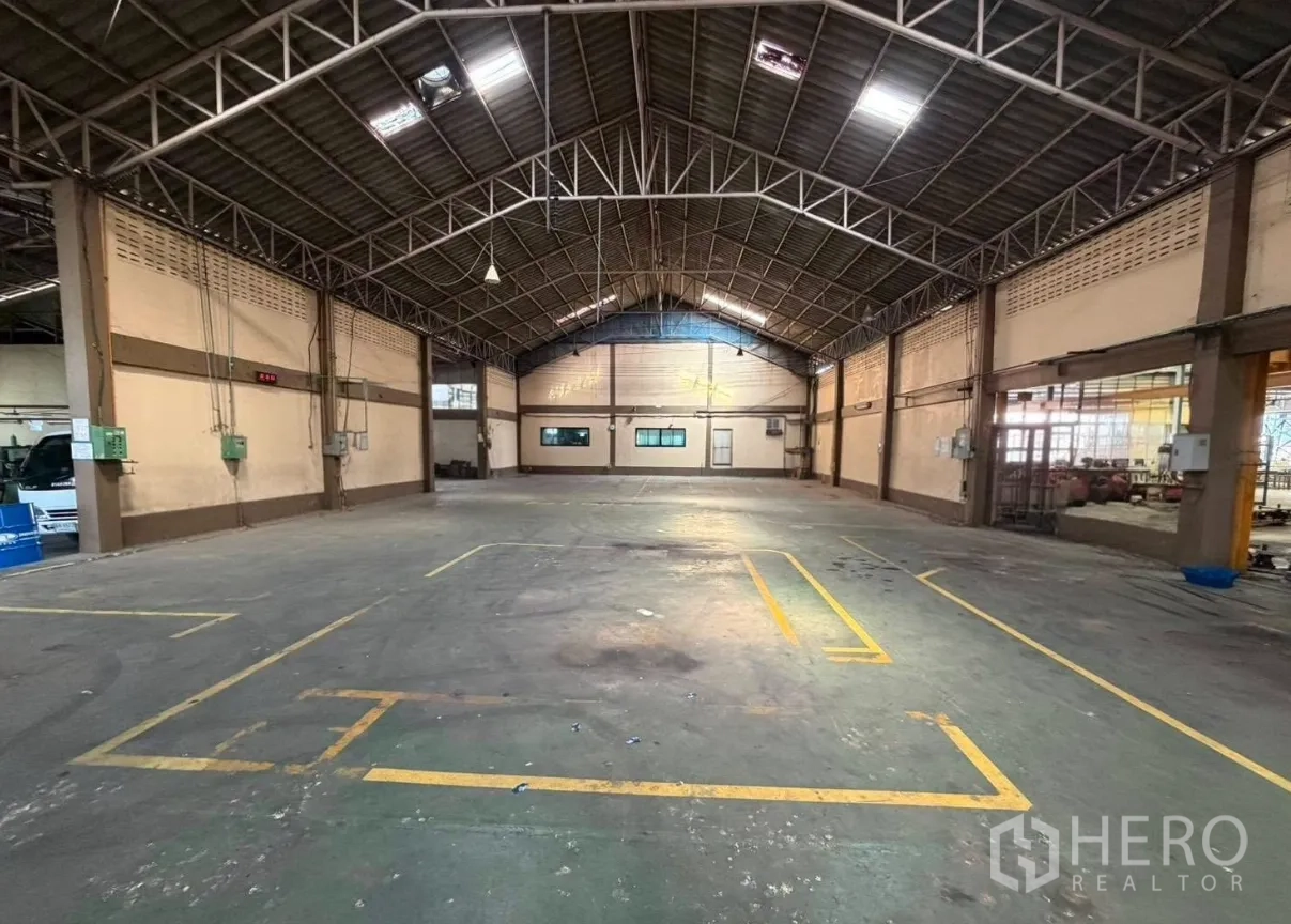 Factory for rent in Bang Phli, Samut Prakan - Warehouse bay with arched truss roof, marked production zones and side windows.