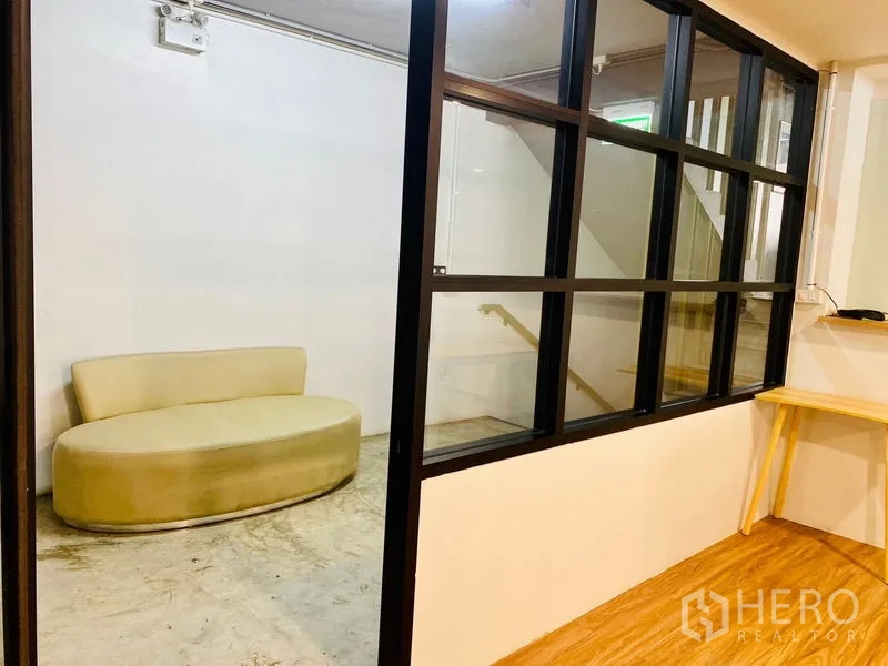 Office Space for rent in Bang Rak, Bangkok - Reception lounge with a glass partition and curved sofa beside the stairs.