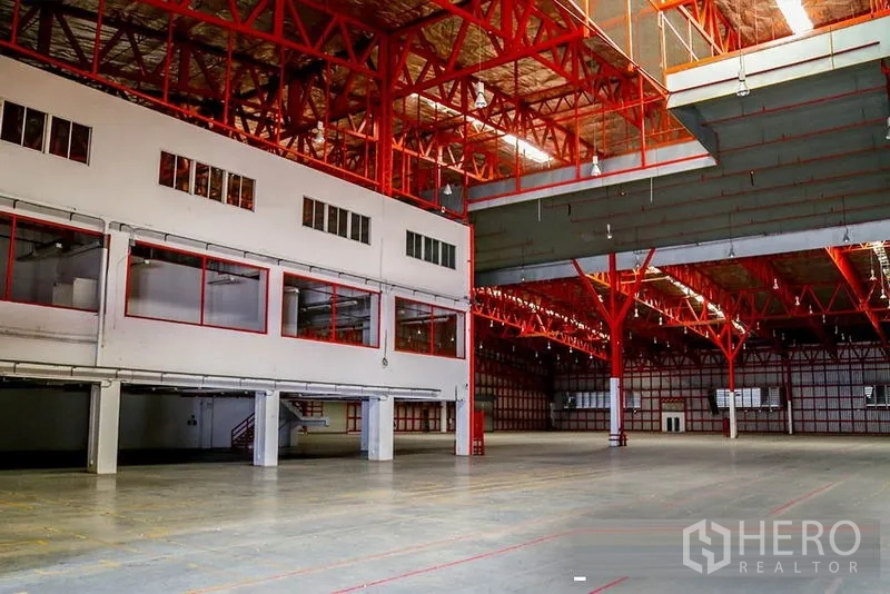 货栈 出租在Samut Prakan - 宽阔仓库地面，带夹层办公室和红色桁架屋顶。
