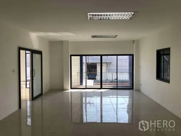 Factory for rent or sale in Bang Phli, Samut Prakan - Spacious upper-floor office with large sliding windows opening to a small balcony rail.